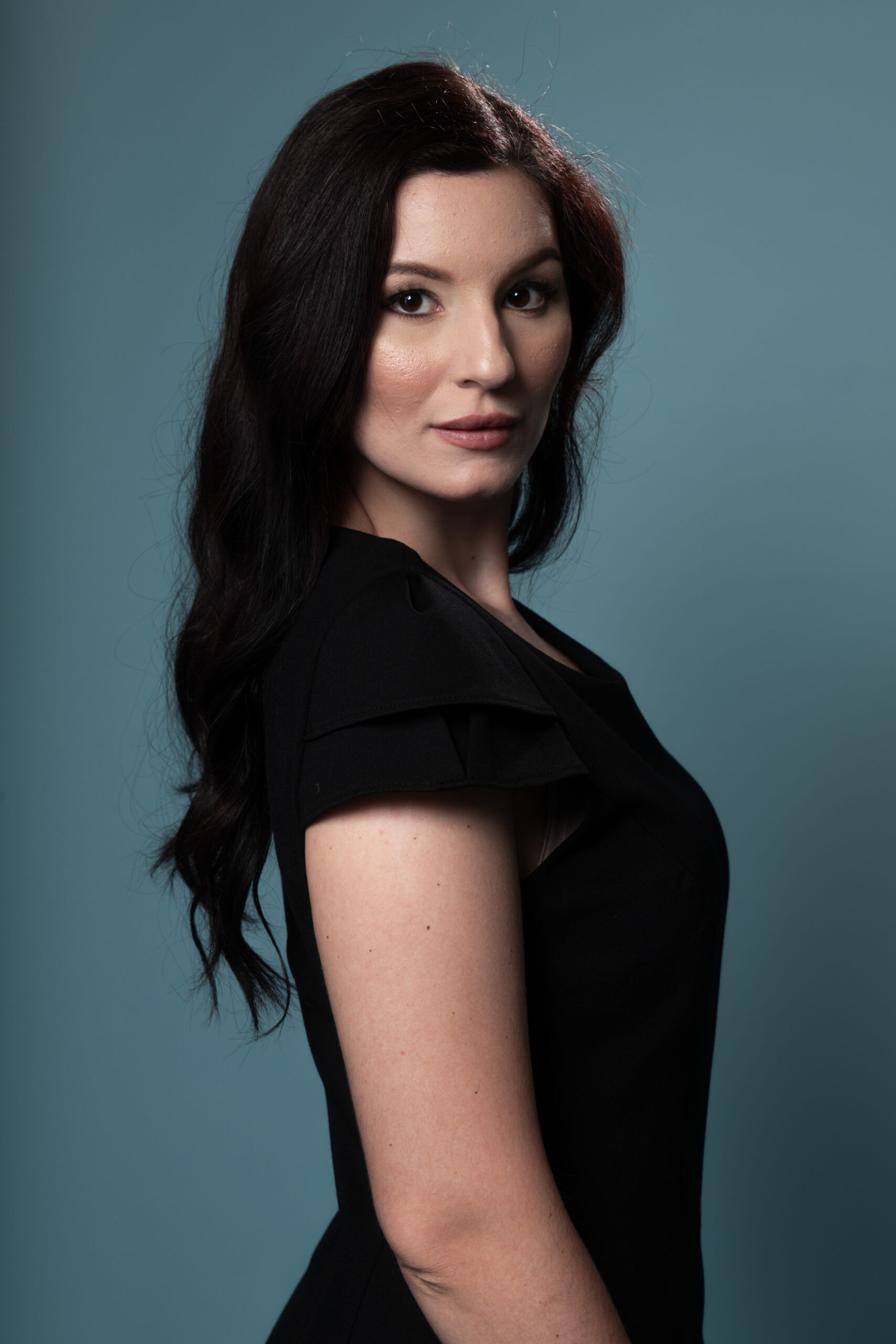 Close-up detail of the Eclipsa Sidera dress, highlighting the double pleated sleeve construction and the subtle texture of the black elastic fabric.