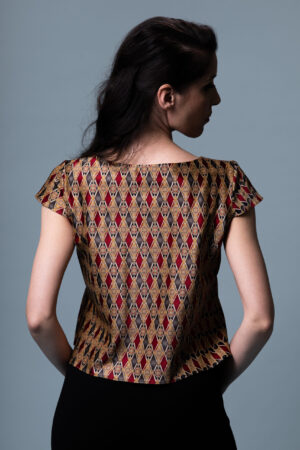 Model wearing the Astrum Sericum pure silk top, illustrating its elegant drape and the striking geometric print.