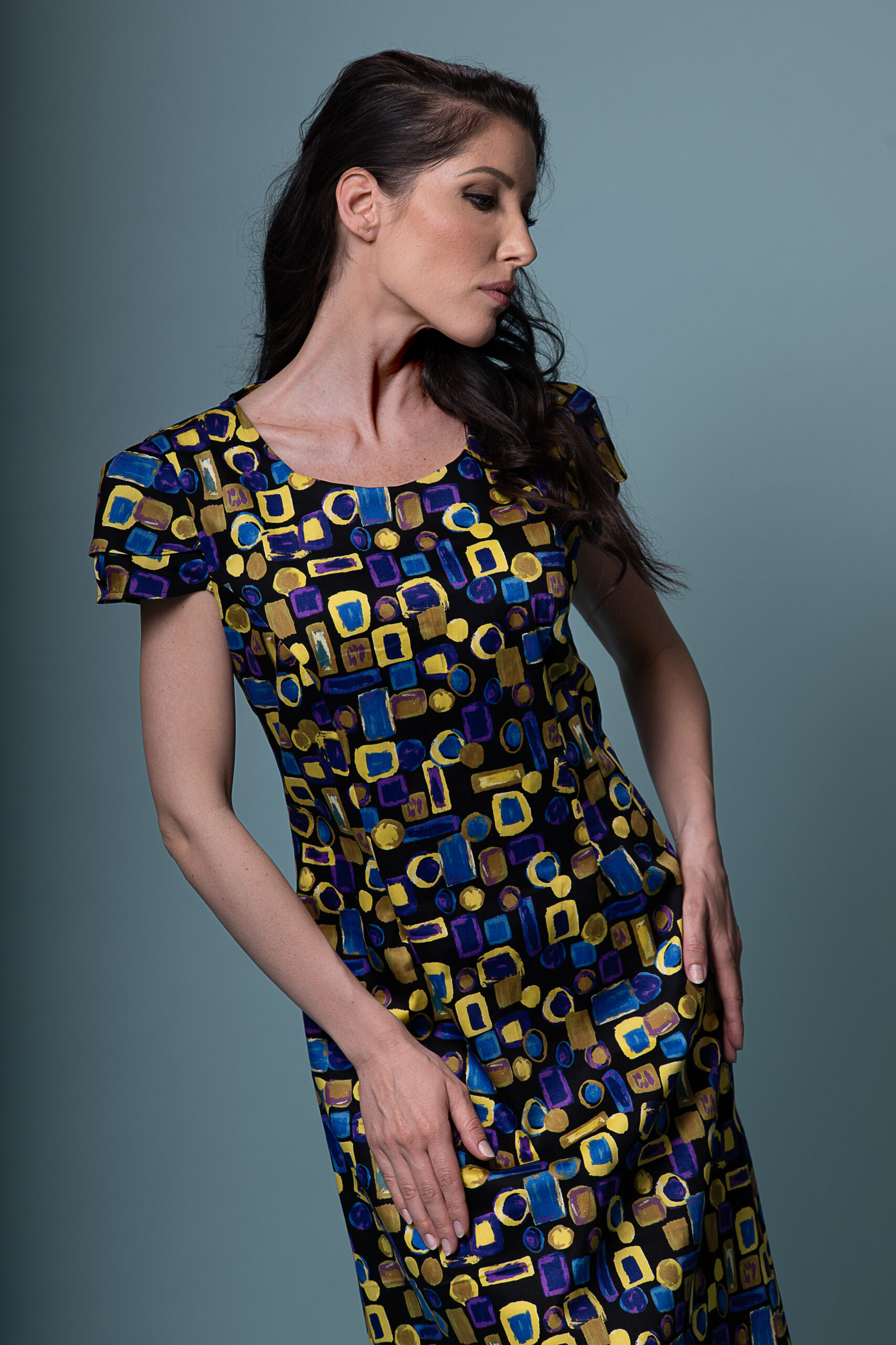 Model wearing the Flos Umbrae dress, full-length shot, capturing the dramatic sleeves.