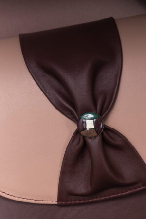 Close-up of the Opacus Leather Bag's sgraffito-enamel button and gathered flap detail.